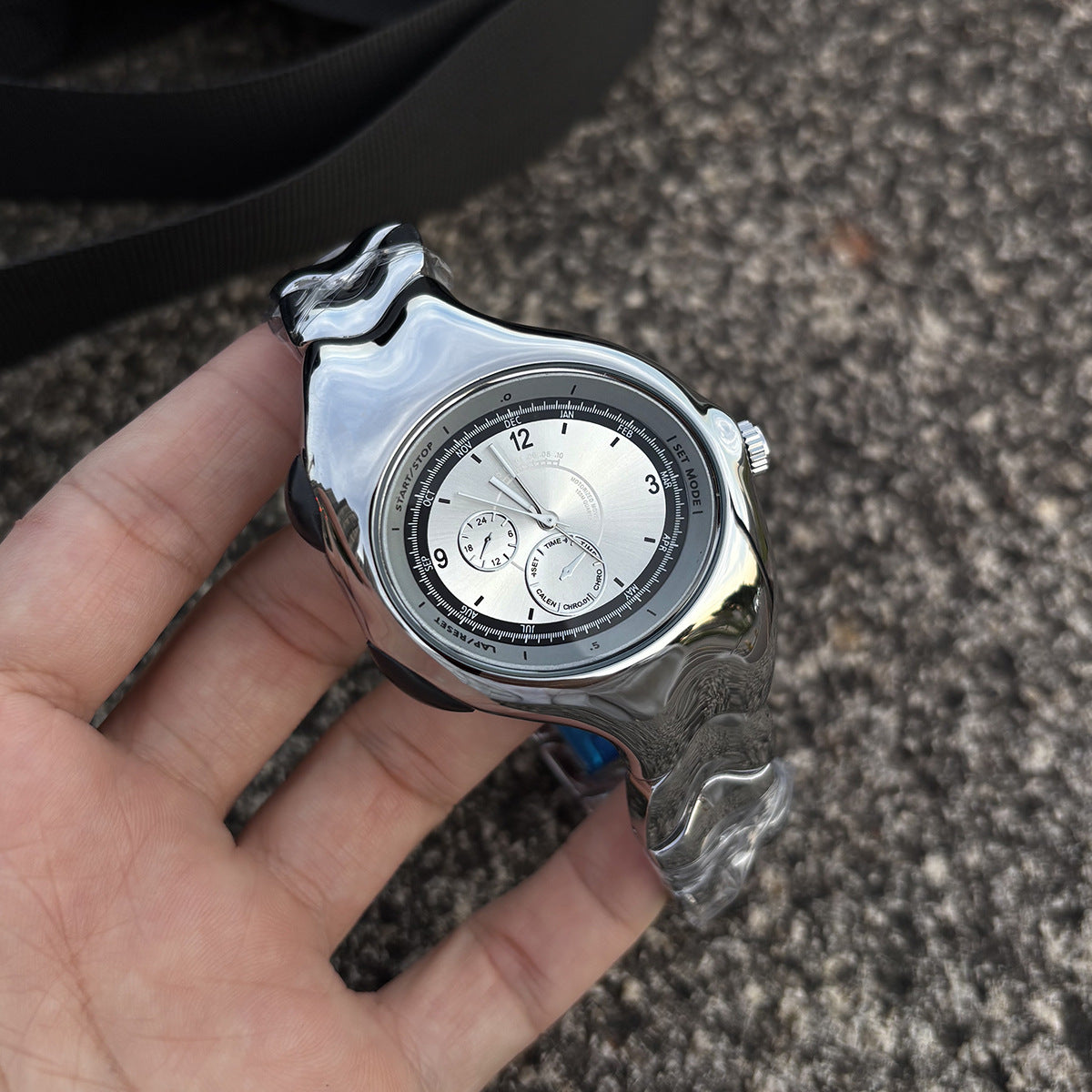Chrono Flux silver Y2K futuristic analog watch handheld close-up