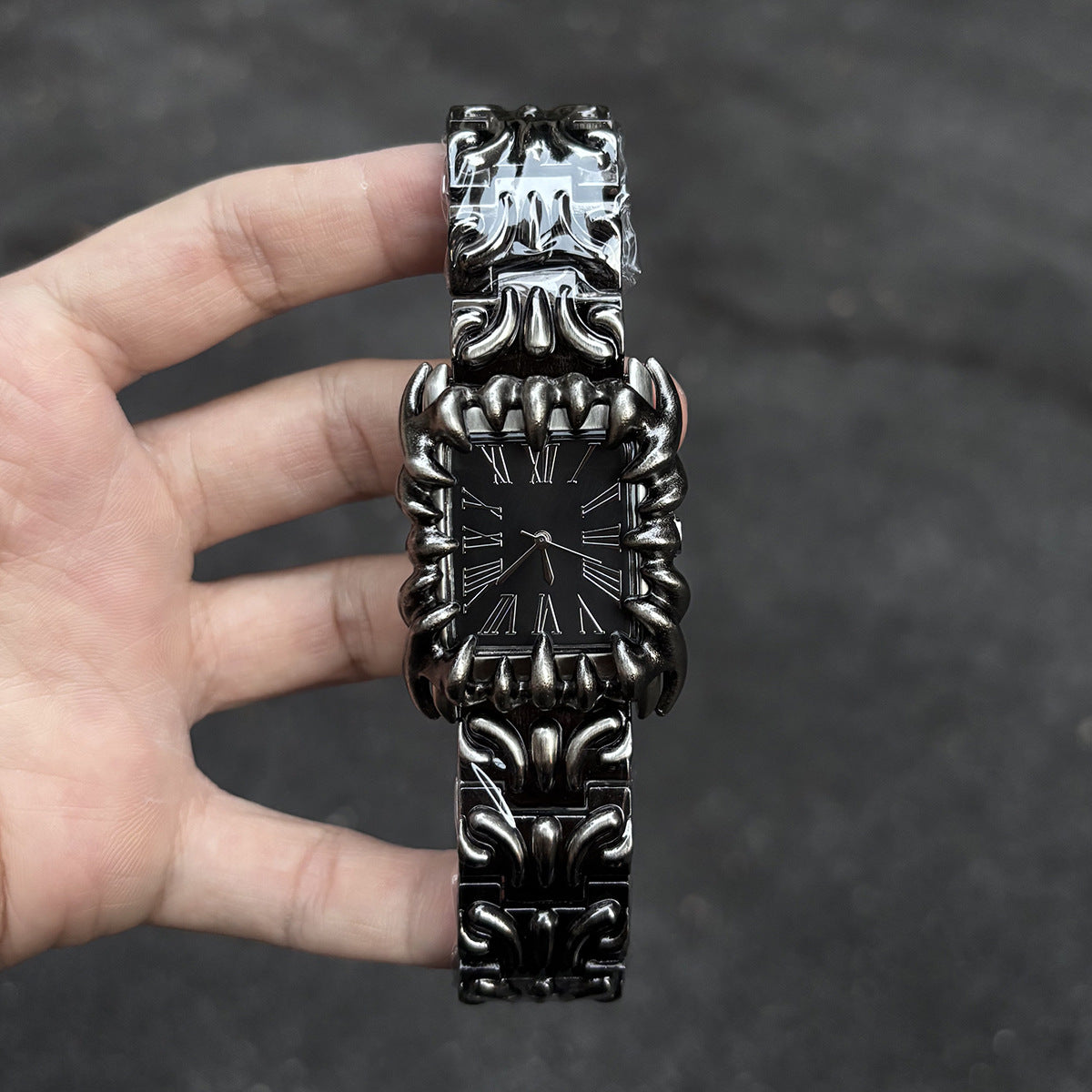 Abyss Grip black dial gothic skeleton claw watch handheld close-up