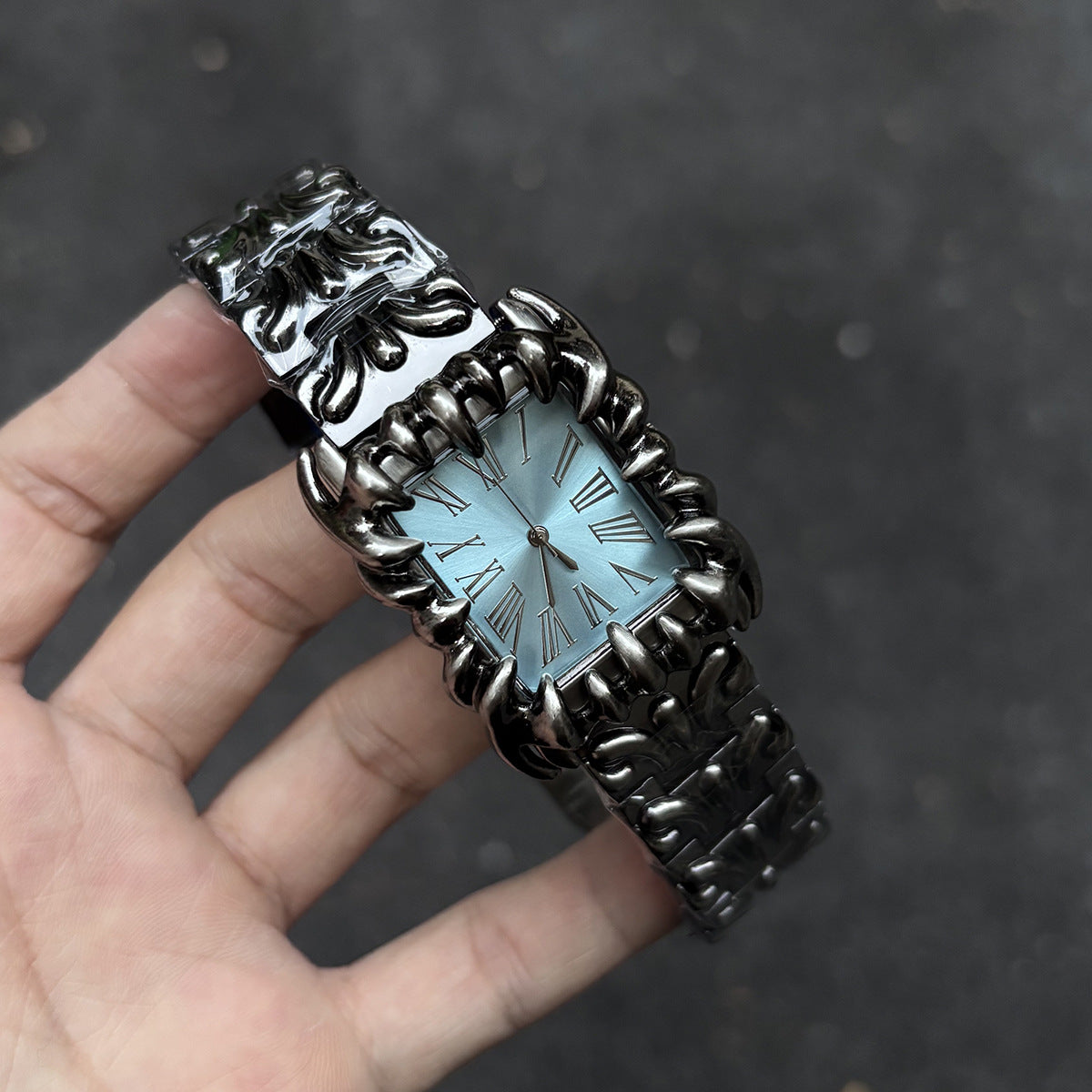 Abyss Grip blue dial gothic skeleton claw watch handheld close-up