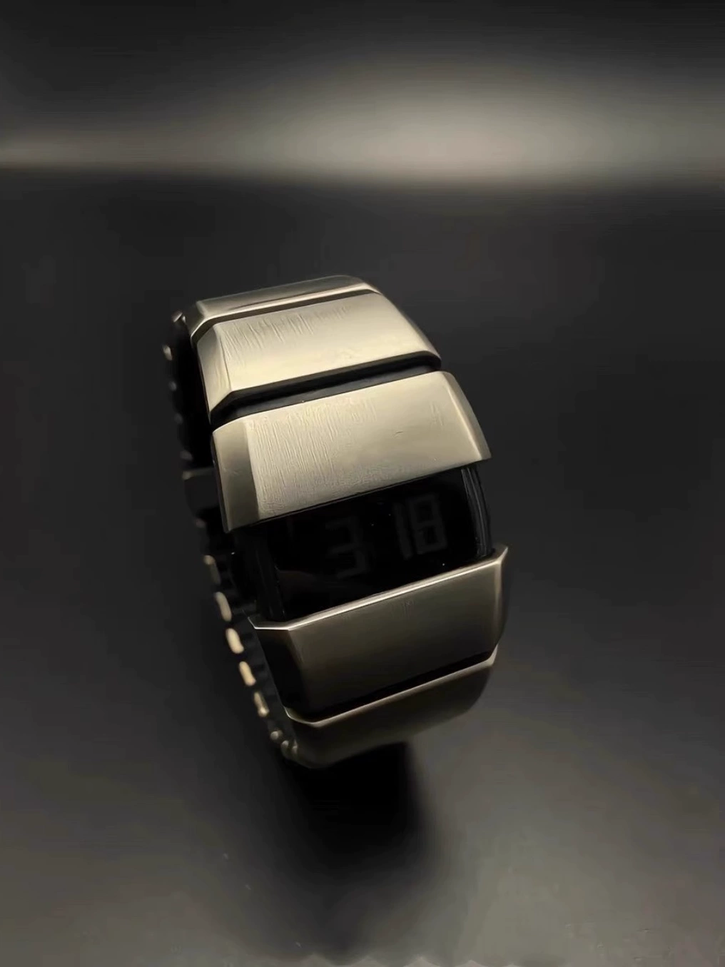 Exoskeleton Link matte silver Y2K futuristic LCD watch displayed on dark surface
