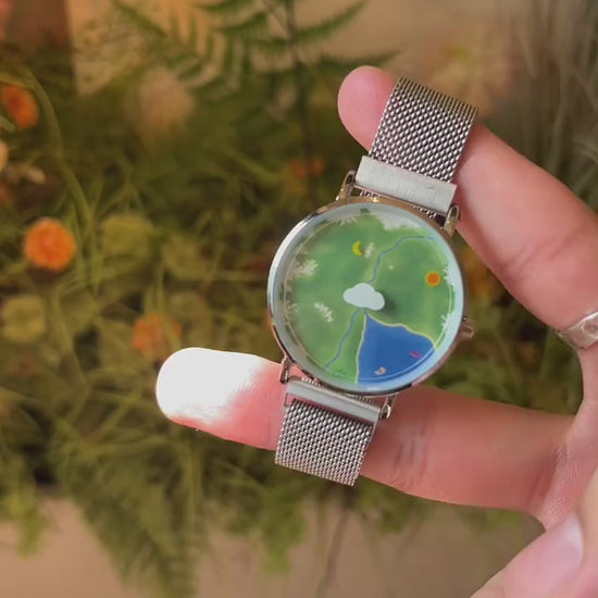 Nature's Orbit watch video showing the Sun hour and Moon minute indicators moving around the Earth landscape dial