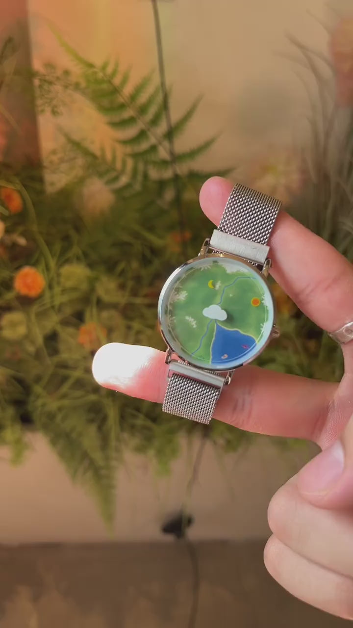 Nature's Orbit watch video showing the Sun hour and Moon minute indicators moving around the Earth landscape dial