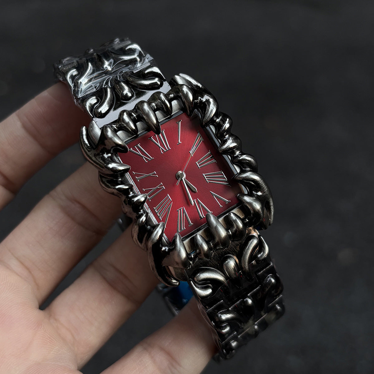 Abyss Grip red dial gothic skeleton claw watch handheld close-up
