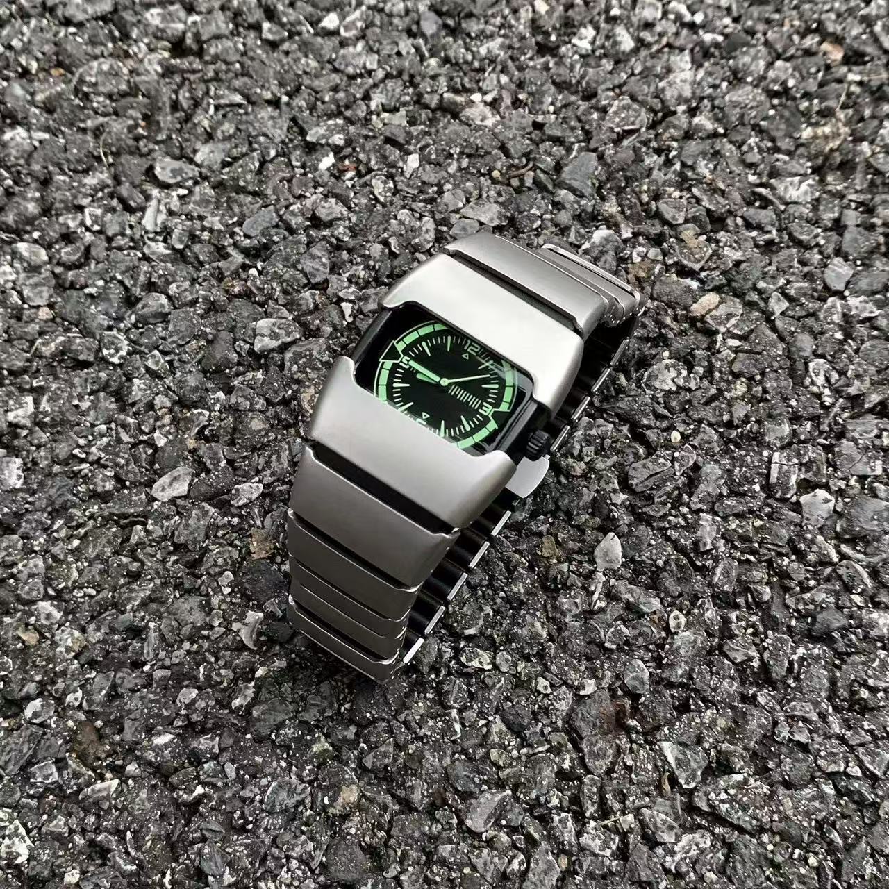 Exoskeleton Link matte silver Y2K futuristic analog watch displayed on gravel