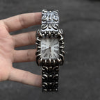 Abyss Grip silver dial gothic skeleton claw watch handheld close-up